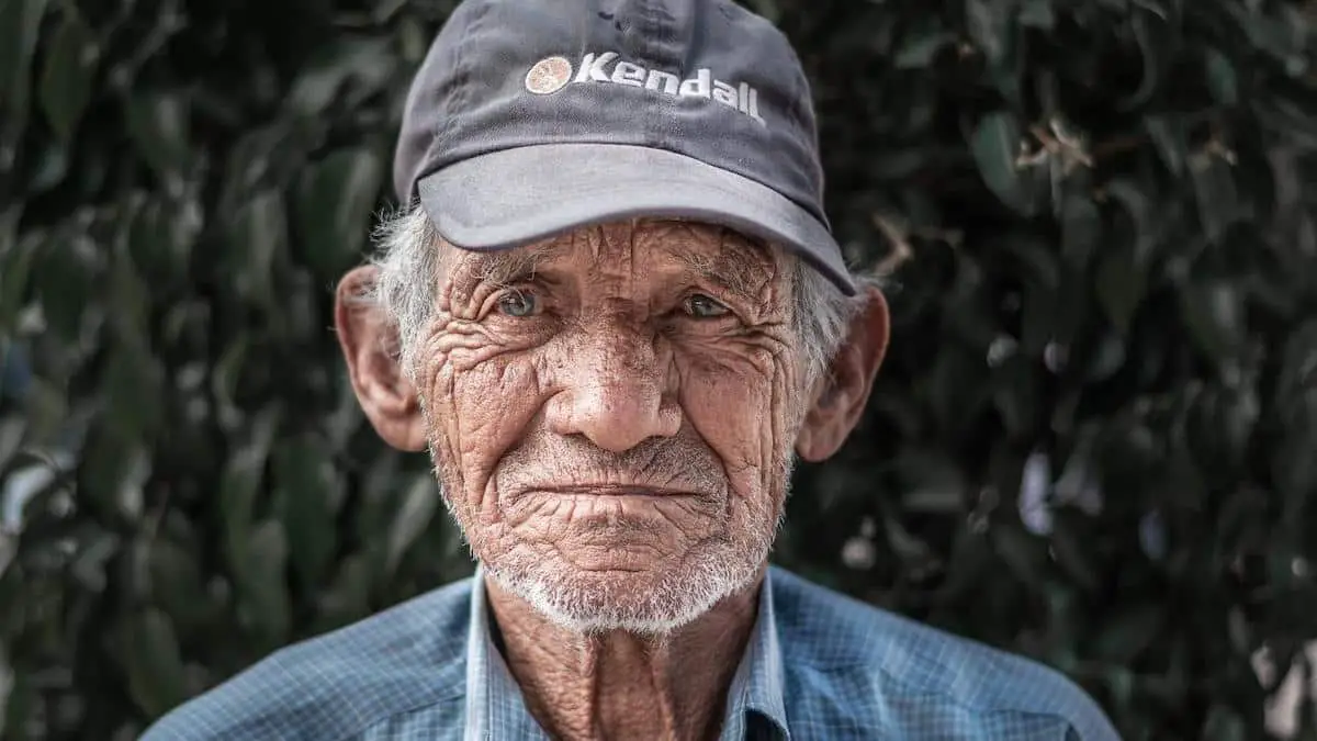 Elderly man wearing a baseball cap.